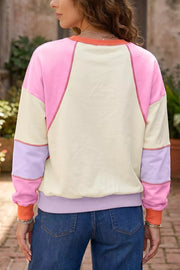 light pink pullover sweater featuring exposed seams and color-block