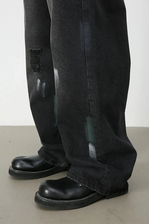 Dark wash wide-leg jeans with distressed details and painterly brushstrokes.