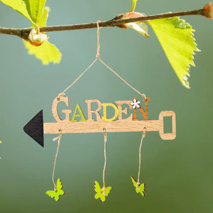 Wooden garden sign with butterflies and arrow detail, hanging from a branch.