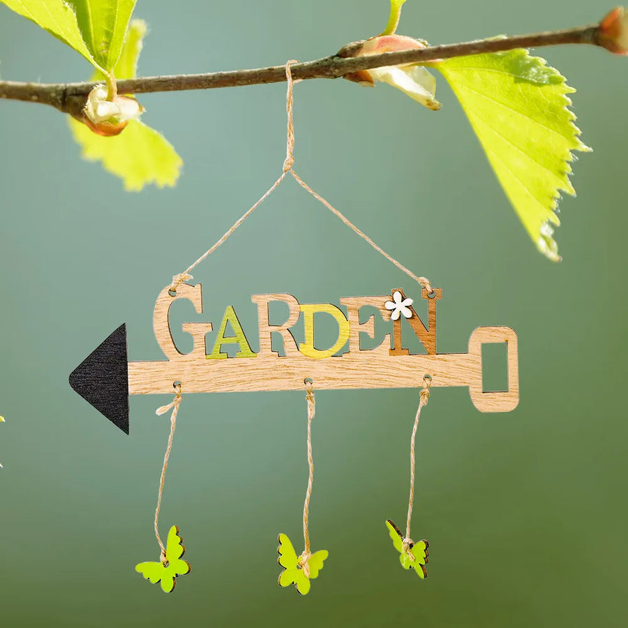 Wooden garden sign with butterflies and arrow detail, hanging from a branch.