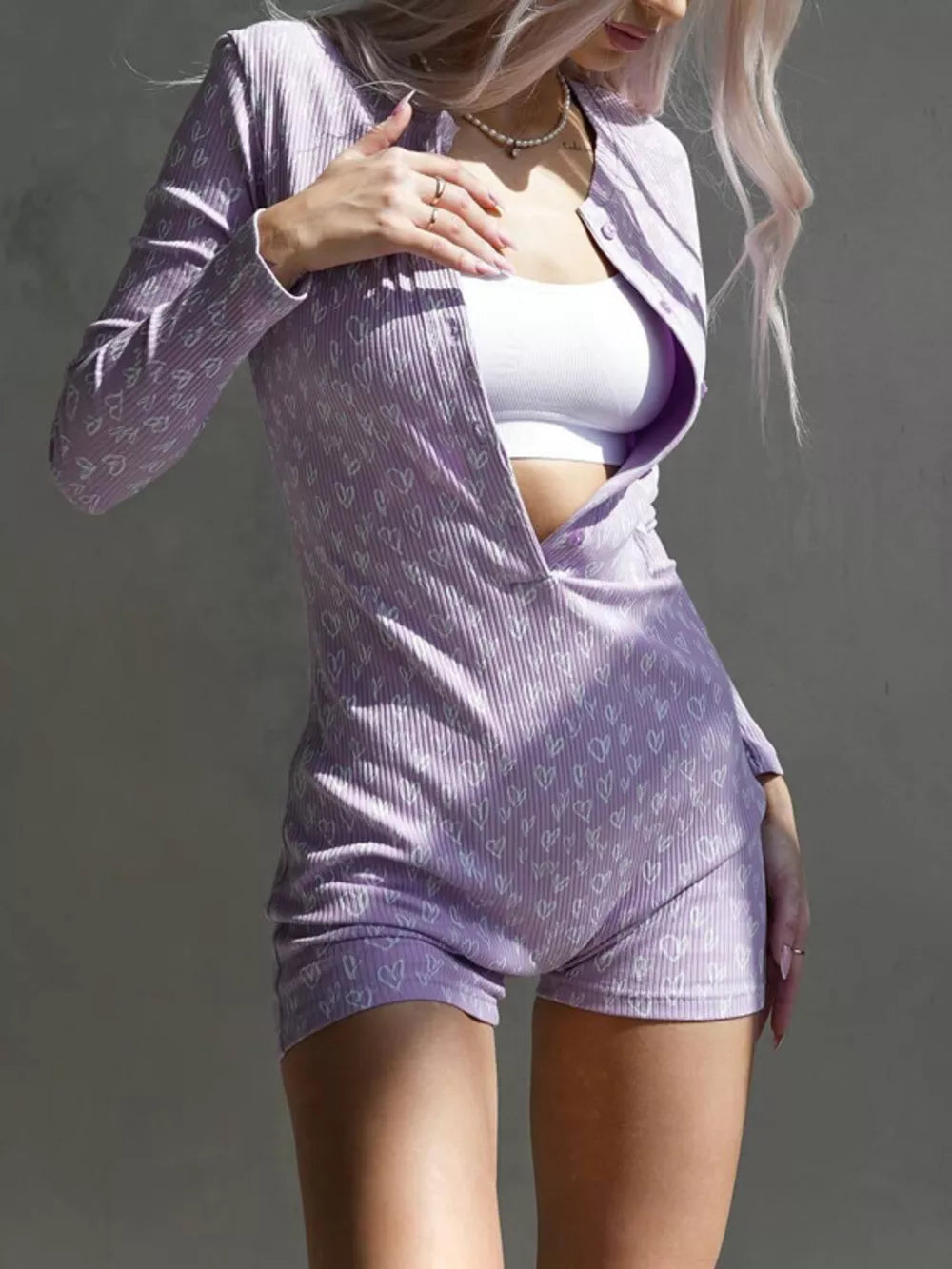 Lavender heart print ribbed knit romper with button front and long sleeves.