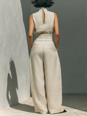 Sleeveless ivory mock-neck top with keyhole back and wide-leg pants with elastic waist.