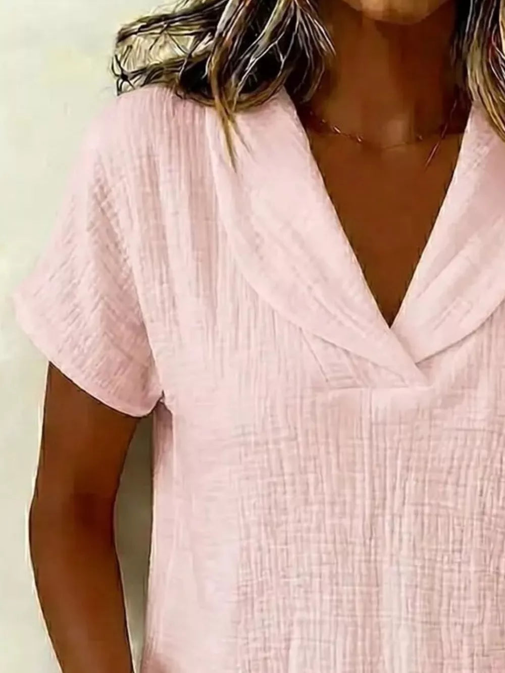 Lotus Color textured blouse with short sleeves and a V-neck collar.
