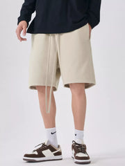 Beige chino shorts with drawstring waist and relaxed fit.