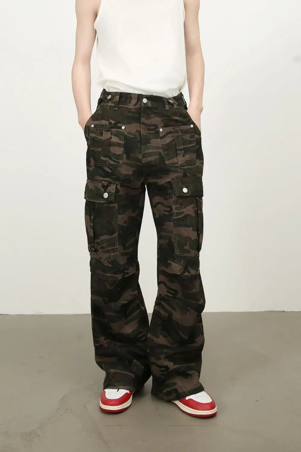 Wide-leg camo cargo trousers in green camouflage with multiple flap pockets.