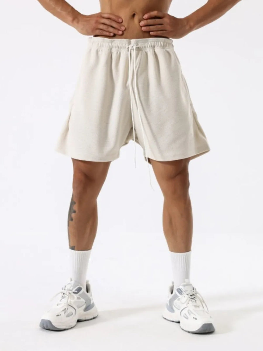 Athletic drawstring lounge shorts in ivory with a textured fabric and relaxed fit.
