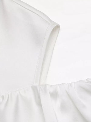 White ruffled cold shoulder maternity blouse with elasticized neckline detail.