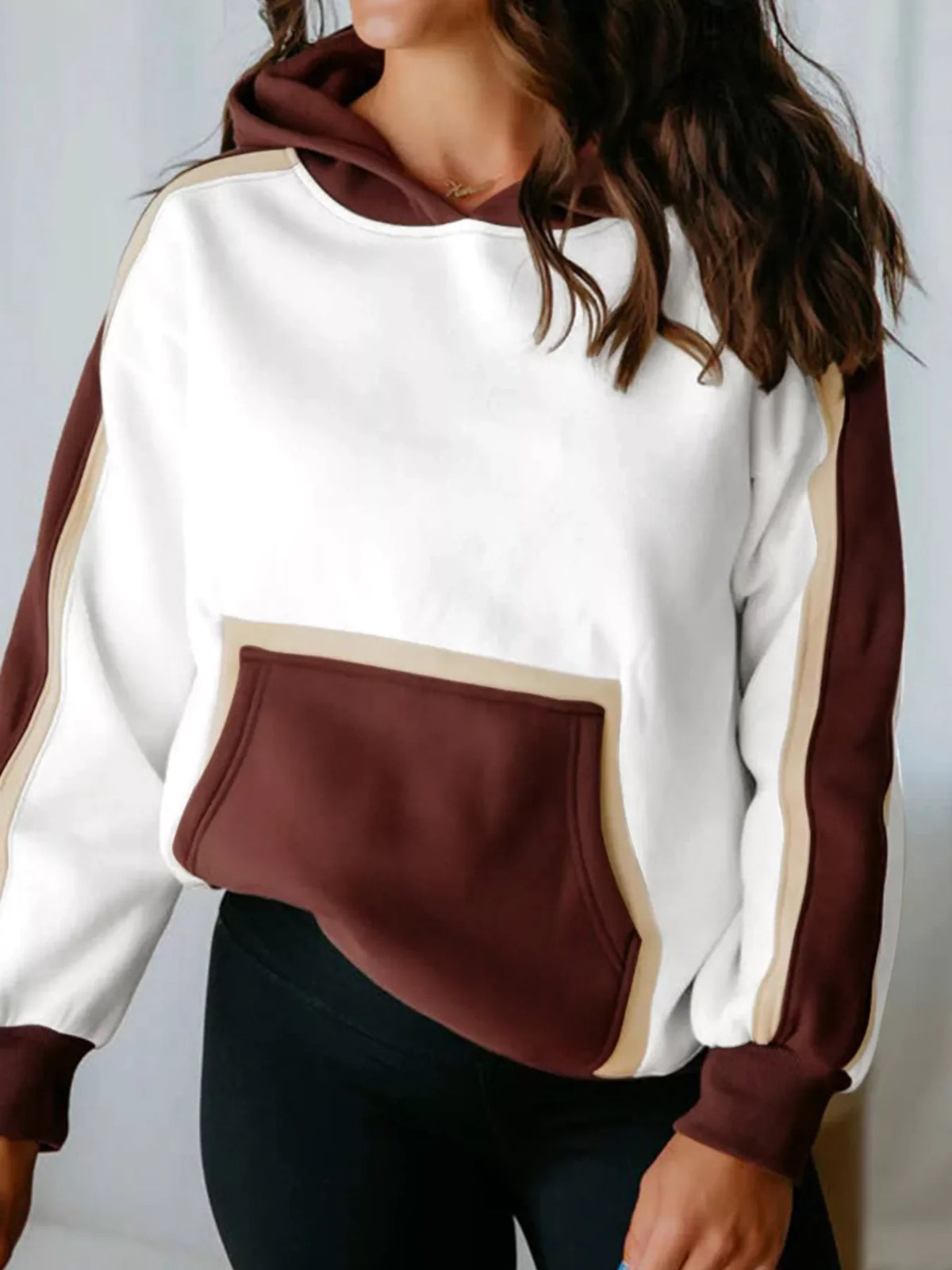 Hooded sweatshirt in white with dark brown and tan accents, featuring a kangaroo pocket and contrast sleeves.