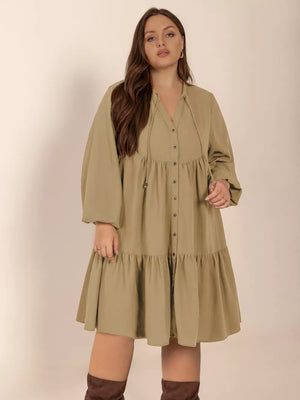 Olive green tie-neck button-front dress with balloon sleeves and tiered skirt.
