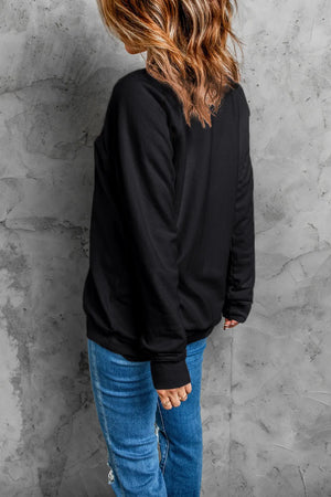 Black crewneck sweatshirt with appliqué detail, long sleeves, and ribbed cuffs.