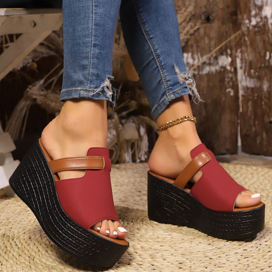 Red open-toe wedge sandals with brown strap detail and black platform sole.