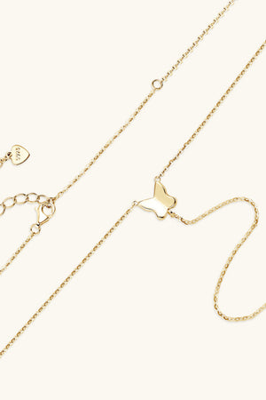 Gold lariat necklace with a butterfly pendant and adjustable clasp.