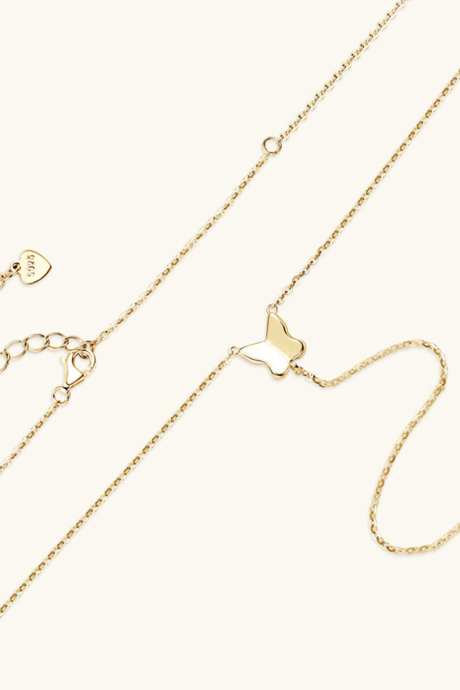 Gold lariat necklace with a butterfly pendant and adjustable clasp.