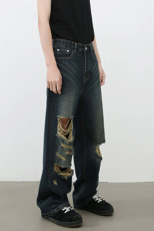 Distressed wide-leg dark wash denim jeans with prominent knee tears and a relaxed fit.