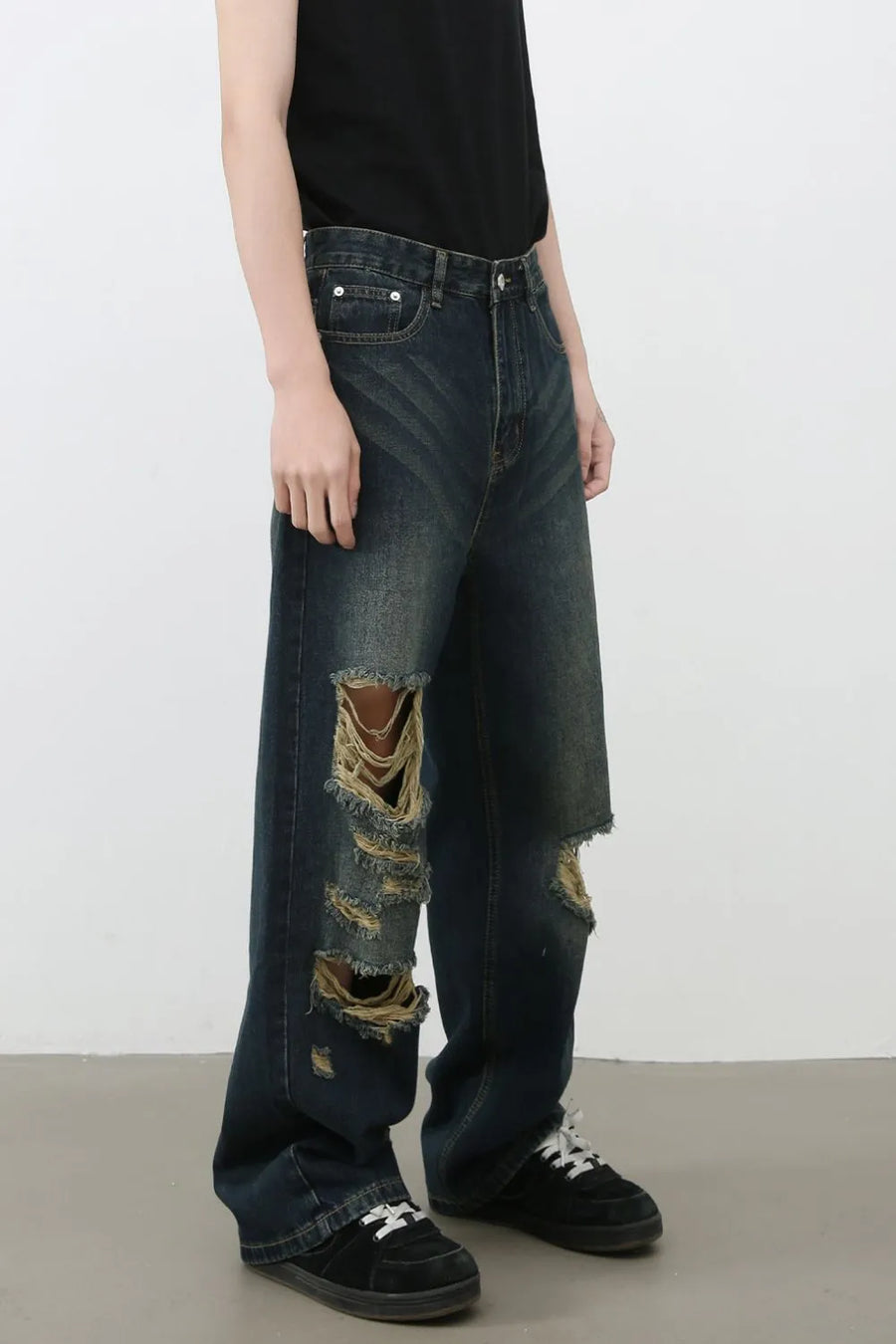 Distressed wide-leg dark wash denim jeans with prominent knee tears and a relaxed fit.