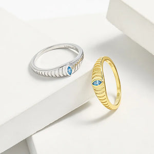 Gold and silver grooved band rings with aquamarine eye detail