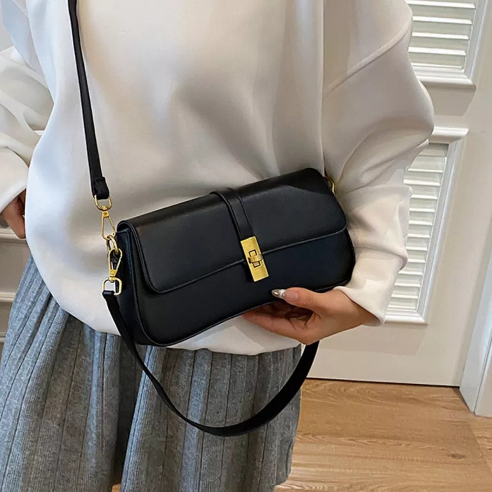 Sleek black rectangular crossbody bag with gold clasp and adjustable strap