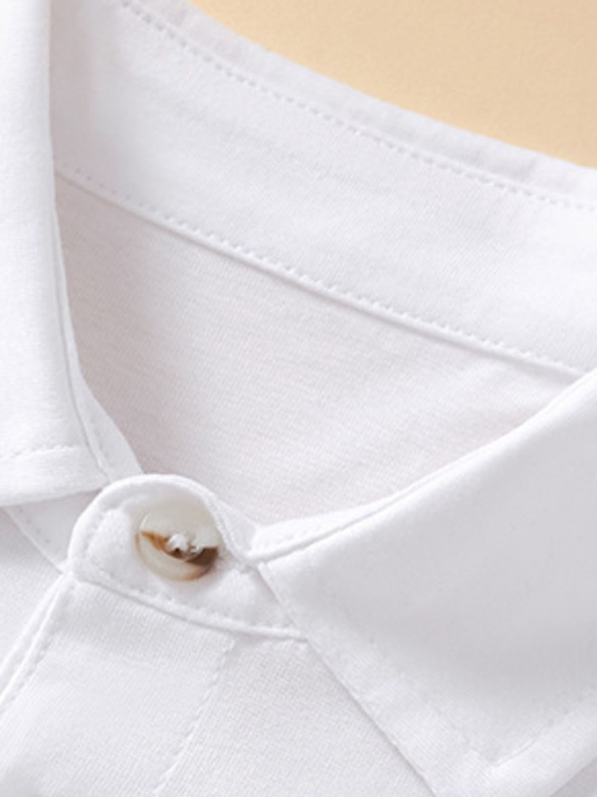 White cotton baby polo shirt with button detail and pocket