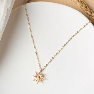 Gold sunburst pendant necklace with delicate chain, 18K gold-plated.
