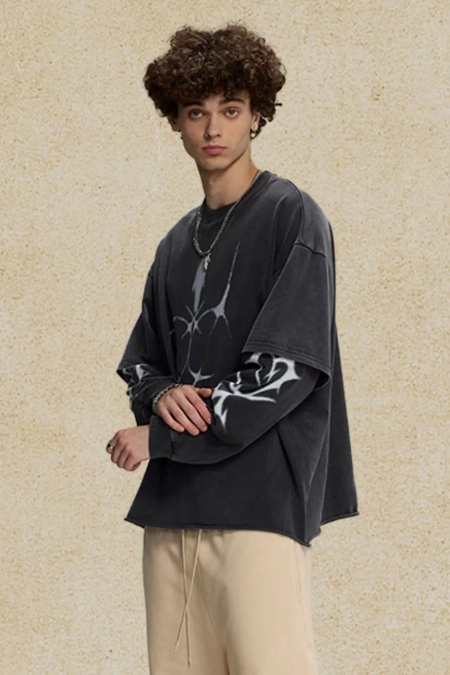 Black distressed graphic tee with layered sleeves and raw hem.