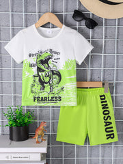 White crew neck t-shirt with dinosaur graphic and green shorts with dinosaur text