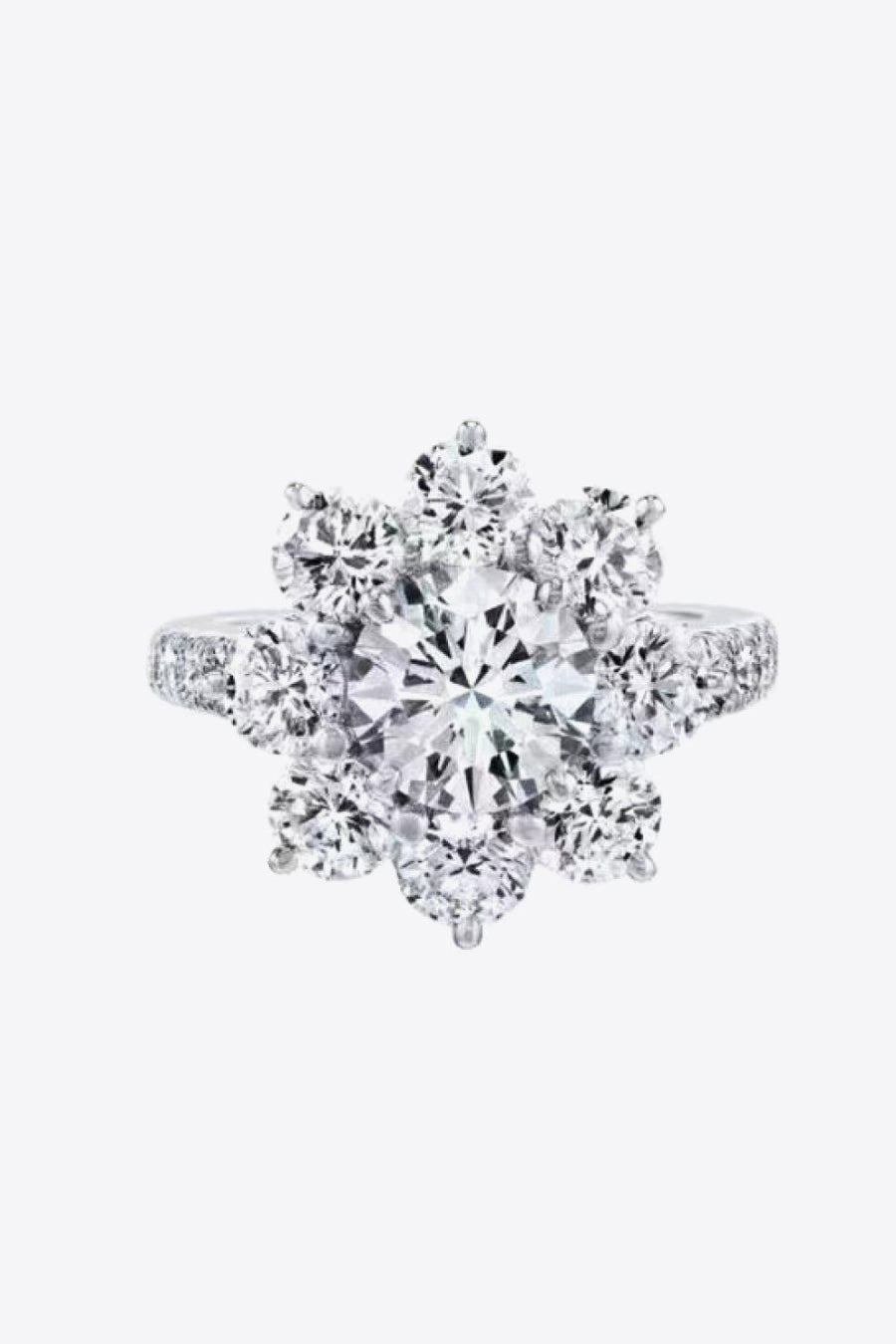Silver moissanite engagement ring with a central round cut stone surrounded by a petal cluster of smaller stones.