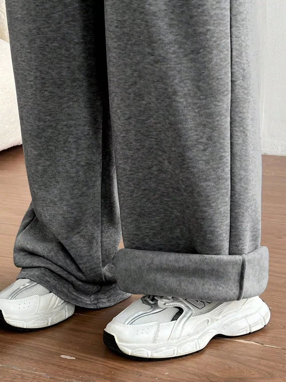 Gray maternity joggers with cuffed hems and wide legs, styled with white sneakers.