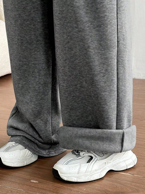 Gray maternity joggers with cuffed hems and wide legs, styled with white sneakers.