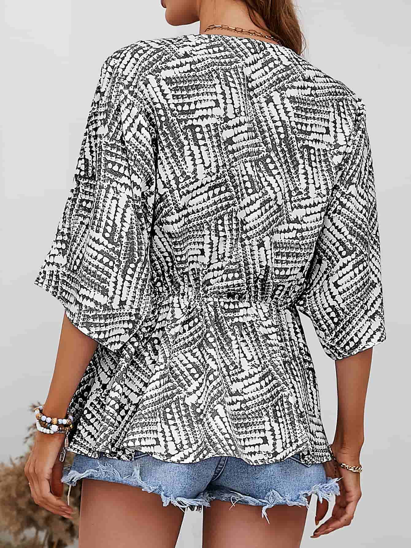 Black and white abstract print cinched waist blouse with 3/4 sleeves.