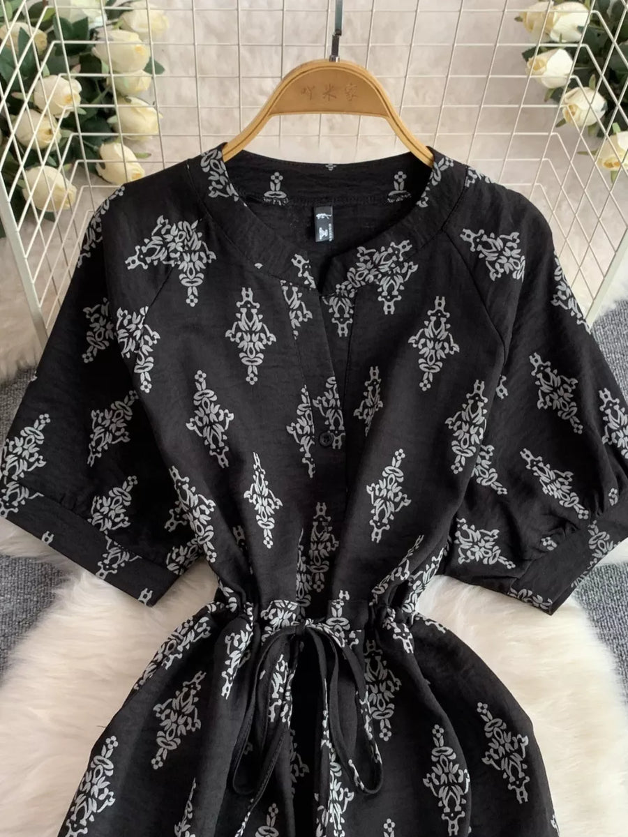 Black printed drawstring jumpsuit with short sleeves and v-neck.