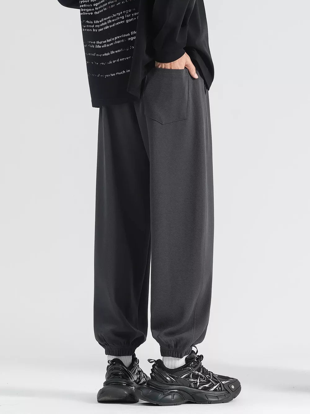 Men's dark gray loose fit sweatpants with drawstring and cuffed ankles.