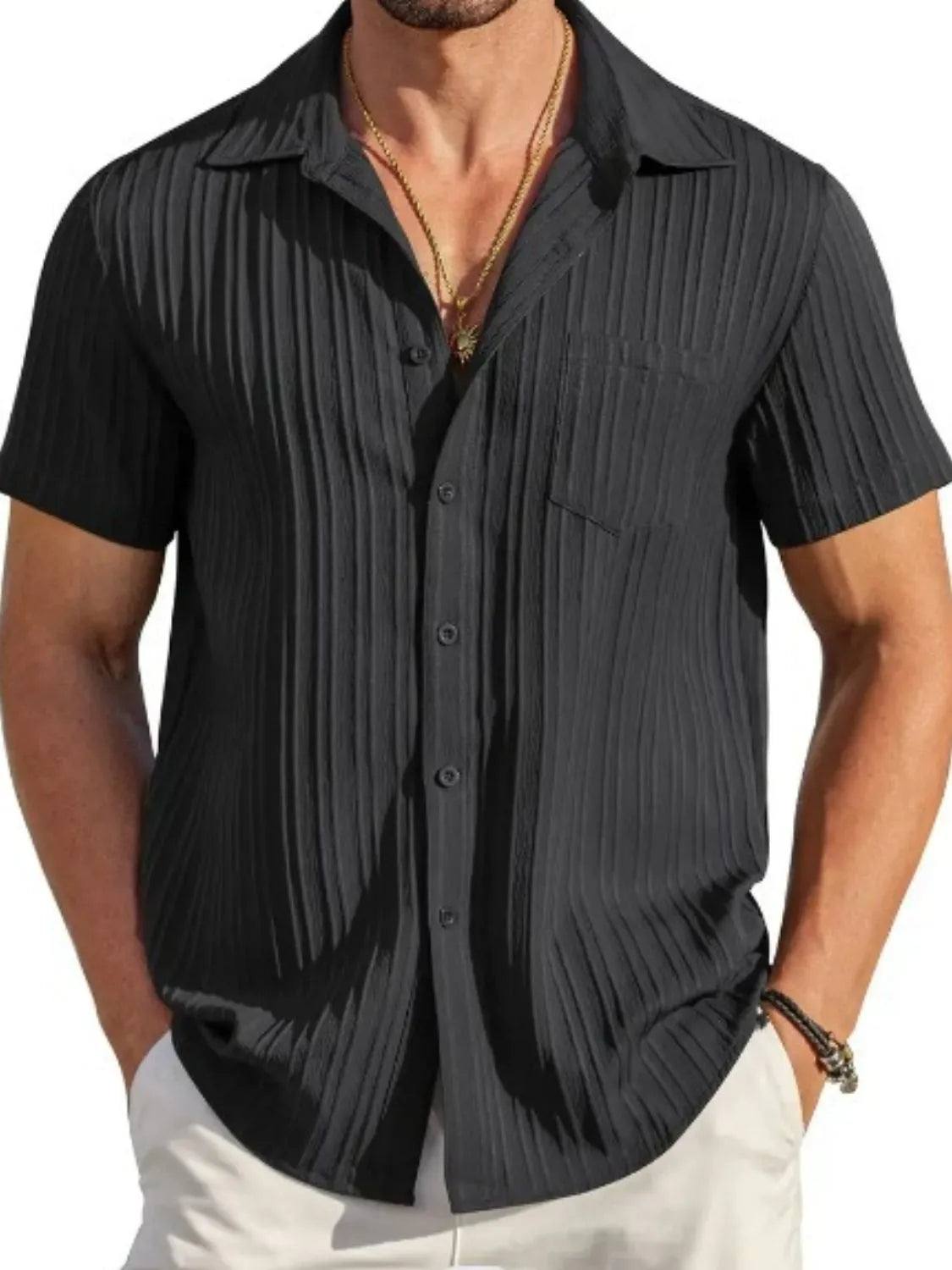Black textured resort shirt with short sleeves and button front, styled with a necklace.