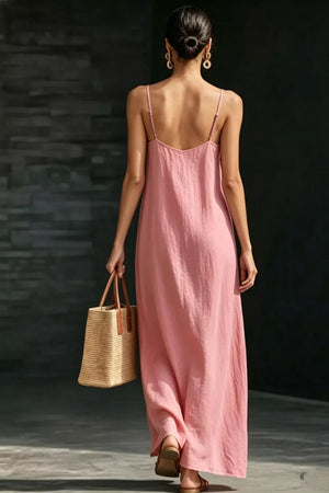 Dusty Pink V-neck maxi dress with spaghetti straps, flowing skirt, and straw tote bag.