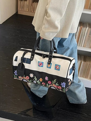 Flower Power large duffel bag in black and white with colorful floral print and embroidered squares.