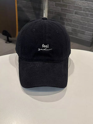 Black baseball cap with white embroidered text detail