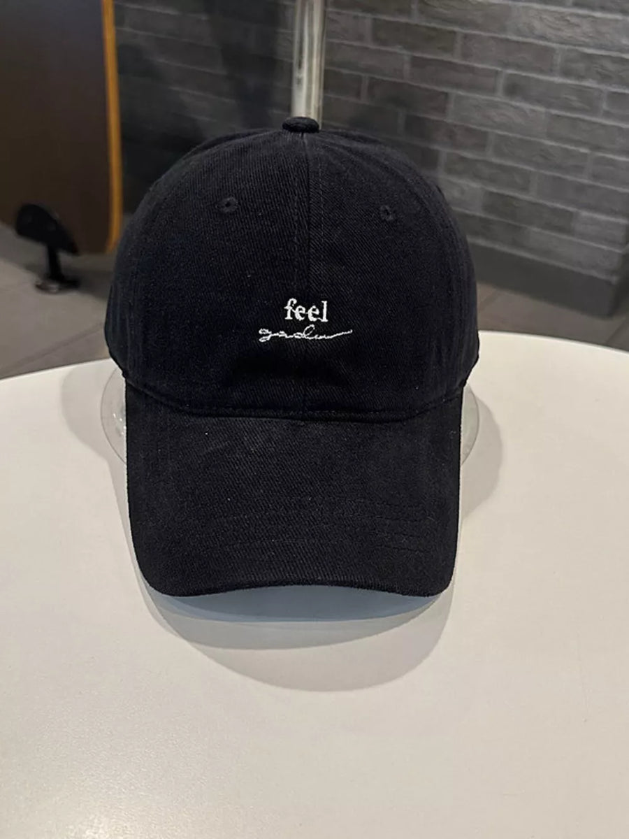 Black baseball cap with white embroidered text detail