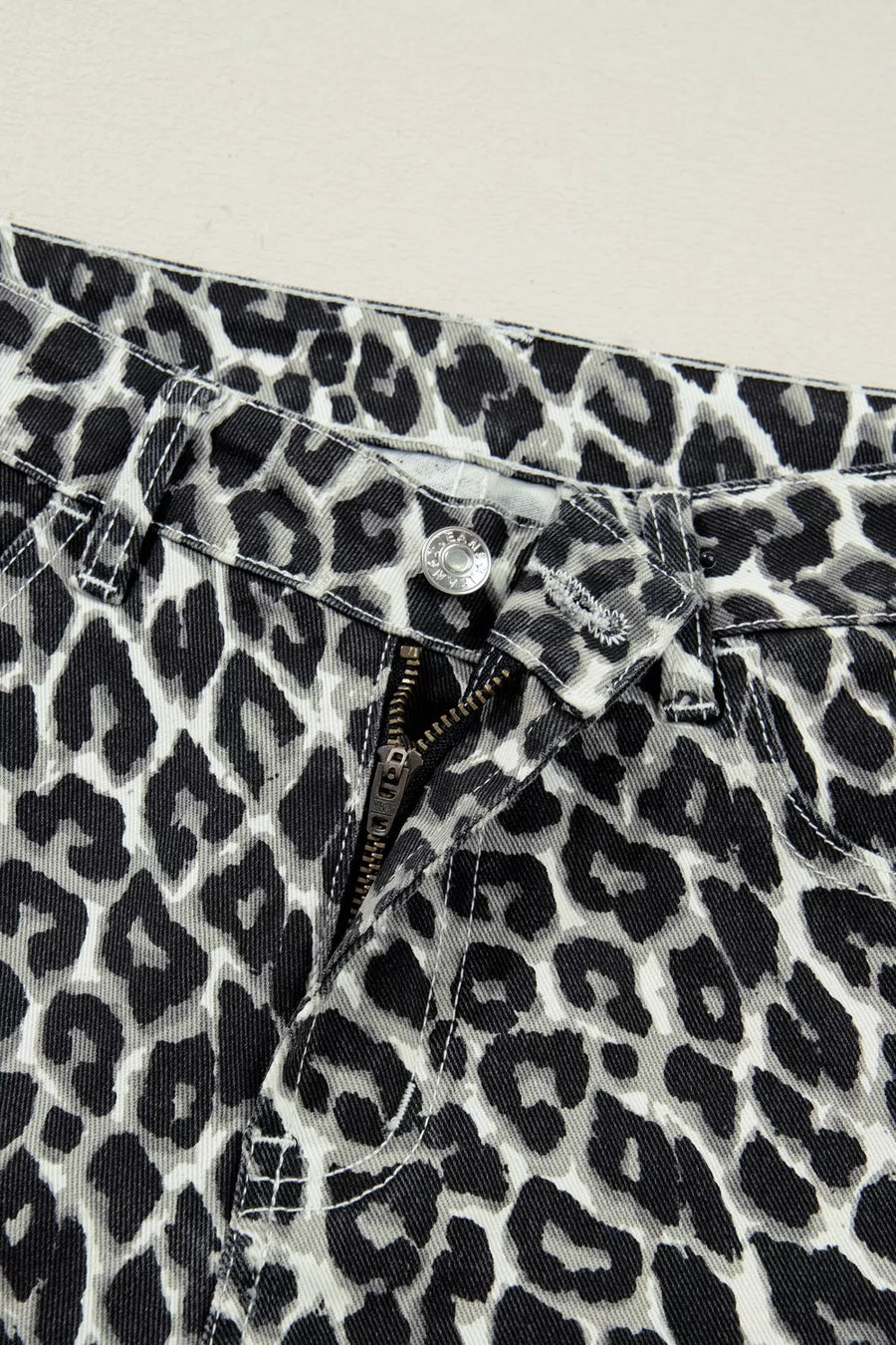 Chic cropped leopard print denim jeans with zip fly and button closure.