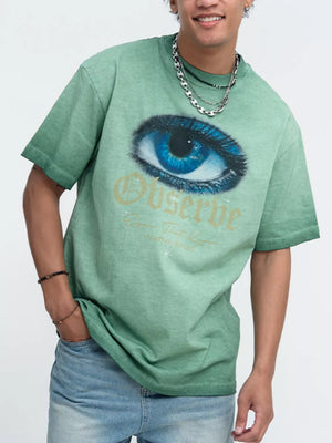 Green graphic tee with eye print and text, crew neck, short sleeves.