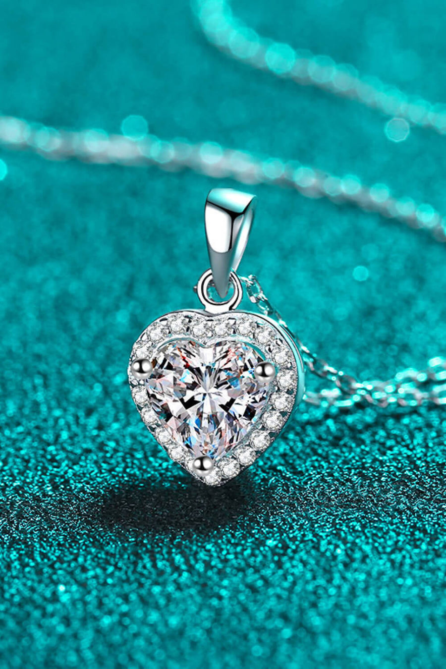 Silver heart cut halo pendant necklace with clear cubic zirconia on a sterling silver chain.