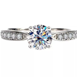 Elegant sterling silver ring with brilliant moissanite center stone and pave band.