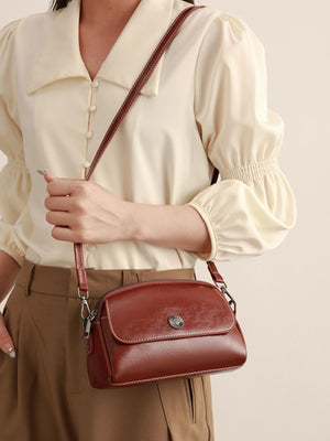 PU Leather Crossbody Bag With Metal Emblem in Brown with metal emblem