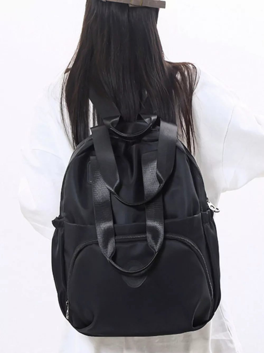 Black Oxford cloth backpack with adjustable straps and multiple pockets.