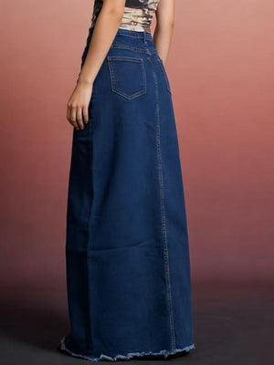 Dark blue denim maxi skirt with raw hem and visible back pockets.