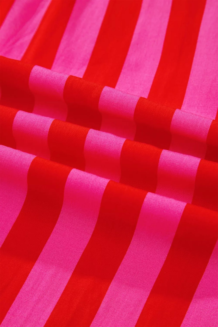 Vibrant puff sleeve shirt in bold red and pink stripes, cotton blend fabric.