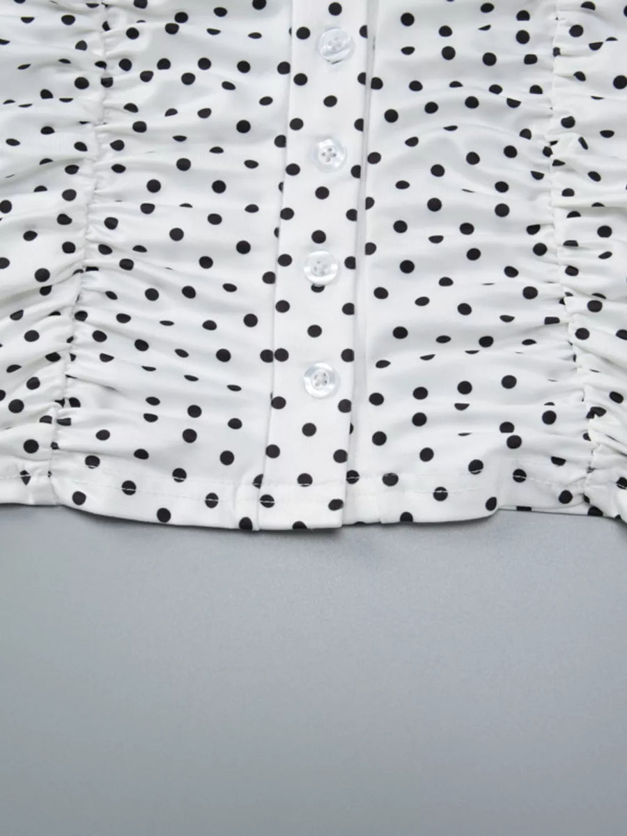 White polka dot t-shirt with ruched sides and button front detail.