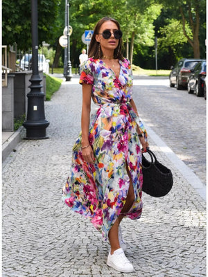 Floral print wrap dress with short sleeves and a high slit, cinched waist with a tie.
