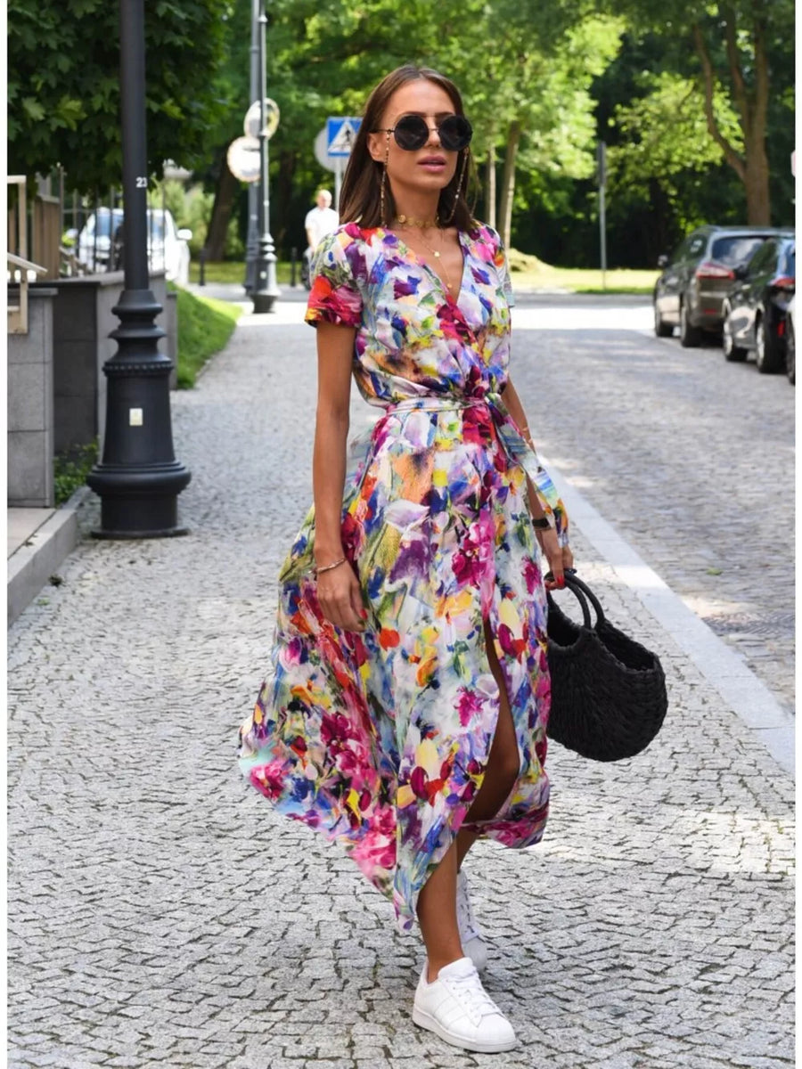 Floral print wrap dress with short sleeves and a high slit, cinched waist with a tie.