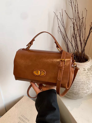 Compact brown pu leather flap shoulder bag with gold turn-lock closure and adjustable strap.