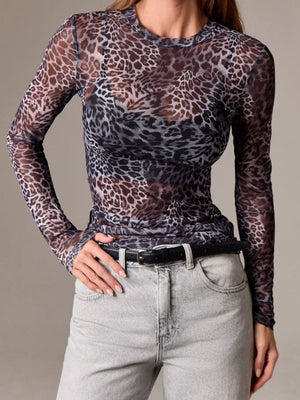 Sheer long-sleeve top with leopard print and crew neck, styled with jeans.