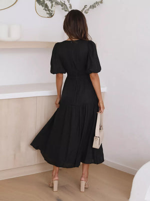 Black puff sleeve midi dress with tiered skirt and cinched waist.